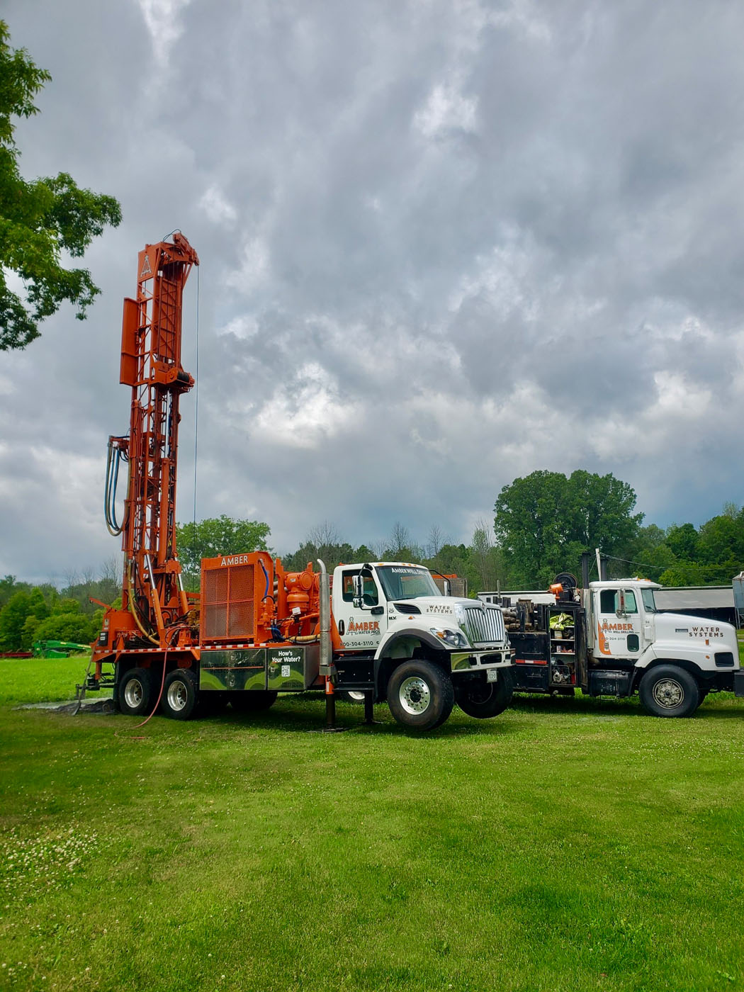 A Amber Water Pros well drilling truck in trees - call Amber Water Pros for New York / Pennsylvania  well and pump repair.